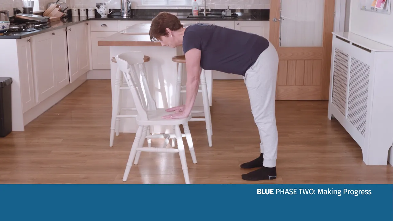 의자 위로 몸을 구부리고 있는 여자