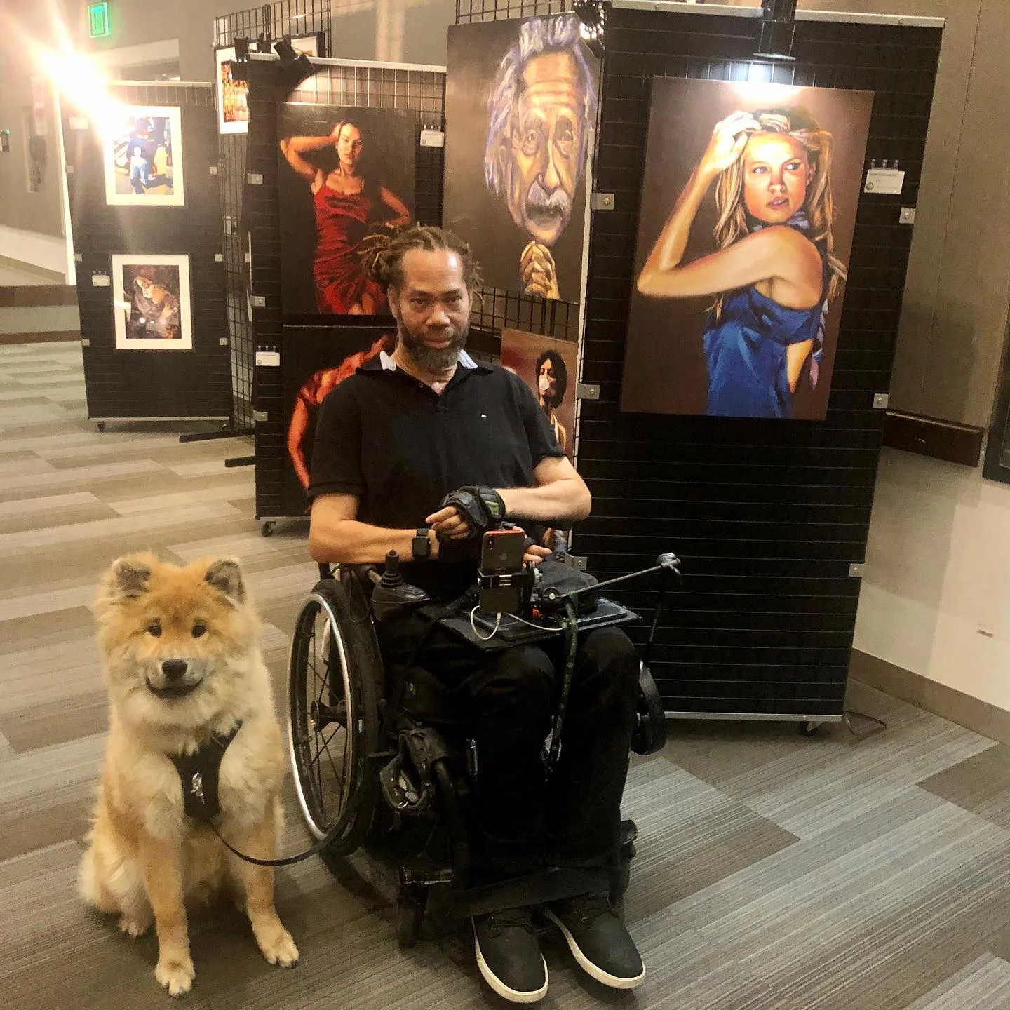 a man in a wheelchair with a dog in front of him